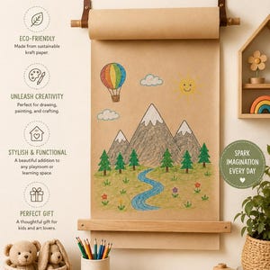 Pu&ograve; includere: Un dispenser da parete per rotoli di carta kraft con asta in legno e cinghie in pelle. La carta presenta un disegno a pastello colorato di montagne, un fiume, una mongolfiera e un sole. Il testo include KIDS ART PAPER ROLL e DRAW, PAINT, IMAGINE!