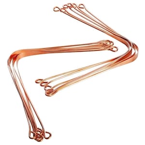 May include: A set of 10 copper tongue scrapers with a U-shaped design and a loop at each end. The scrapers are arranged in a curved shape, with the loops at the top and the ends of the scrapers at the bottom.