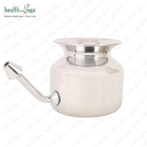 May include: A stainless steel neti pot with a spout for nasal irrigation. The pot has a rounded body and a wide opening at the top.