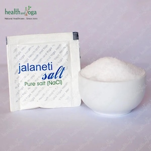 Puede incluir: Un paquete blanco de sal jalaneti, etiquetado como "Sal pura (NaCl)" con la marca "health and yoga" en el frente. Un pequeño tazón blanco lleno de sal blanca está al lado del paquete.