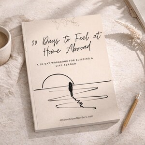 Könnte beinhalten: Ein beigefarbenes Arbeitsbuch mit dem Titel 30 Days to Feel at Home Abroad: A 30-Day Workbook for Building a Life Abroad. Das Cover zeigt eine schwarze Strichzeichnung einer Person, die auf einen Sonnenuntergang zugeht, sowie die Website Athomebeyondborders.com.
