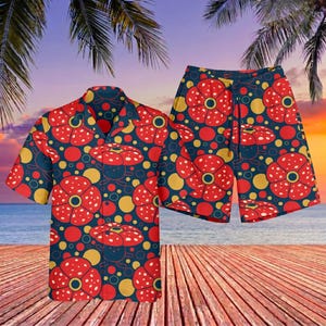 May include: A matching short-sleeve button-down shirt and shorts set. The set features a repeating pattern of red and yellow mushroom-like shapes on a navy blue background. The outfit is displayed on a wooden deck with a beach and sunset backdrop.