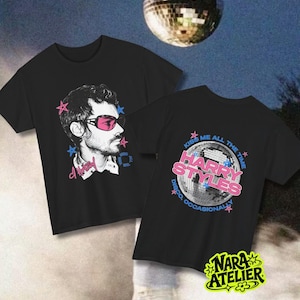 Puede incluir: Dos camisetas negras con estampados gráficos. Una muestra una ilustración de perfil de una persona con gafas de sol rosas y estrellas rosas y azules. La otra muestra una bola de discoteca con el texto HARRY STYLES, KISS ME ALL THE TIME.