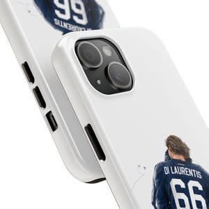 May include: White phone case featuring a close-up of a blue jersey with the name "DI LAURENTIS" and the number "66". The case also displays the word "LAURENTIS" and the number "99" in a circular design. The phone's camera and buttons are visible.