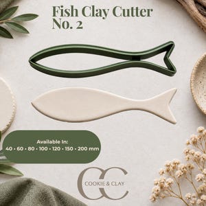 May include: A dark green fish-shaped clay cutter and a corresponding beige fish-shaped clay cutout. The text reads Fish Clay Cutter No. 2 and Available In: 40, 60, 80, 100, 120, 150, 200 mm. The logo for Cookie & Clay is visible at the bottom.
