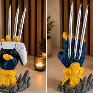 May include: A blue and yellow sculpted hand stand featuring three long silver metallic claws extending upward. The hand is mounted on a gray rocky base and is shown holding a white and black video game controller in one view and displaying the back of the hand in another.