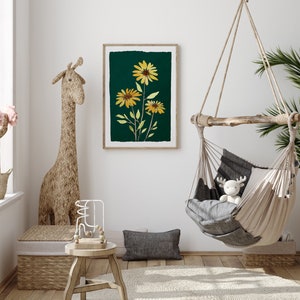 Puede incluir: Una impresi&oacute;n enmarcada de una ilustraci&oacute;n bot&aacute;nica con tres girasoles amarillos sobre un fondo verde oscuro. La impresi&oacute;n est&aacute; colgada en una pared blanca en una habitaci&oacute;n con una silla hamaca colgante y un animal de peluche con forma de jirafa.