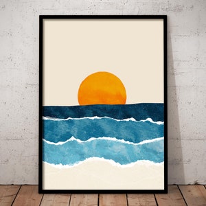 May include: Abstract art print featuring a large orange sun setting over a blue and white ocean. The print has a minimalist style and is perfect for a modern home.