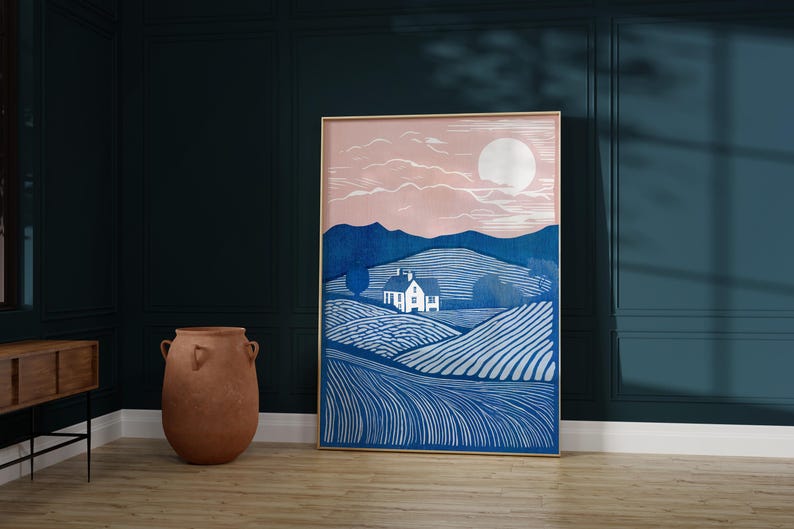 Puede incluir: Una impresi&oacute;n enmarcada de un paisaje azul y blanco con una peque&ntilde;a casa blanca y una gran luna blanca en el cielo. El cielo es de color rosa claro.