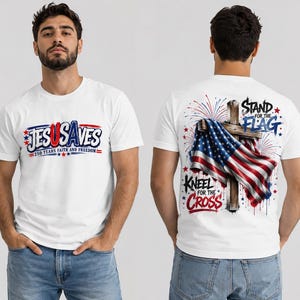 Peut inclure: Un t-shirt blanc avec un motif frontal indiquant "JESUSAVES 250 YEARS FAITH AND FREEDOM" en bleu et rouge. Le dos présente une croix en bois drapée d'un drapeau américain, des feux d'artifice et le texte "STAND FOR THE FLAG KNEEL FOR THE CROSS."