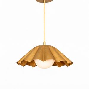 May include: Gold-toned pendant light with a ruffled shade and a spherical, frosted glass globe. The light fixture hangs from a slender rod and a circular ceiling mount. The shade has a textured, metallic finish.