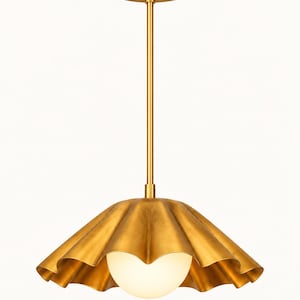 May include: A brass pendant light fixture featuring a wide, scalloped metal shade with a brushed gold finish. A single, spherical white glass globe bulb is centered within the shade, suspended from a matching brass rod and circular ceiling canopy.