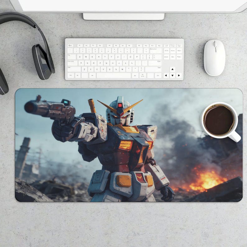 May include: A rectangular desk mat featuring a detailed illustration of a Gundam robot holding a weapon, set against a backdrop of a war-torn environment with flames and smoke. A cup of coffee sits on the right.