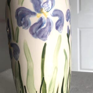 May include: A set of three ceramic canisters with lids. The canisters are white with a blue floral pattern. The largest canister is 20 cm tall, the medium is 18 cm, and the smallest is 15 cm.