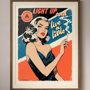 Könnte beinhalten: Gerahmter Vintage-Poster-Druck im Retro-Comic-Stil. Es zeigt eine Frau in einem blauen Kleid, die eine Zigarette hält, mit den Worten "LIGHT UP and live a little". Das Kunstwerk hat eine klassische Ästhetik.