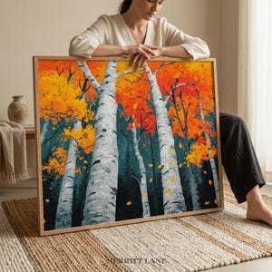 May include: A framed art print featuring a vibrant autumn forest scene. Tall birch trees with white bark stand out against a backdrop of orange and yellow foliage. The artwork is in a wooden frame, with the text "MERRITT LANE" at the bottom.