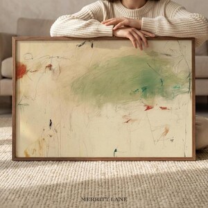 May include: Abstract art print in a wooden frame. The artwork features a cream-coloured background with green, red, and black brushstrokes. The text "MERRITT LANE" is at the bottom of the frame.