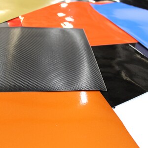 May include: A selection of coloured vinyl sheets, including black, blue, orange, red, gold, and a carbon fibre pattern.