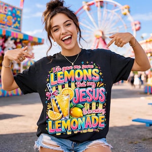 K&ouml;nnte beinhalten: Schwarzes T-Shirt mit einem farbenfrohen Aufdruck mit der Aufschrift "Life gave me some LEMONS But my JESUS He be making LEMONADE". Das Design zeigt ein Glas Limonade, Zitronenscheiben und eine ganze Zitrone. Die Person tr&auml;gt das Shirt und l&auml;chelt.