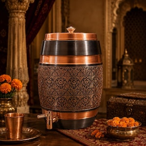 May include: A barrel-shaped copper and black metal water dispenser featuring an intricate embossed floral pattern around the center, a matching copper lid with a small knob, and a copper spigot attached to the lower front section.
