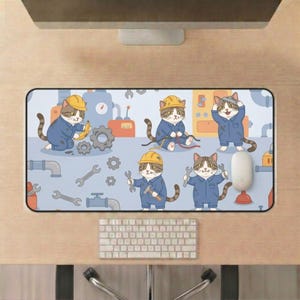 May include: A rectangular mousepad featuring a cartoon design of cats dressed as mechanics. The cats are wearing blue overalls and yellow hard hats, holding tools like wrenches and bananas. The background is light blue with mechanical elements.