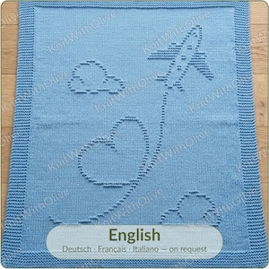 May include: A light blue knitted blanket featuring a textured pattern of an airplane flying through the sky. The airplane leaves a trail that forms a heart shape, accompanied by two clouds. The blanket has a wide, textured border along all edges.