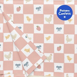 Pode incluir: Um tecido com um padrão de xadrez rosa e branco com ilustrações repetidas de galinhas castanho-claras, pintainhos amarelos, laços azuis e morangos cor-de-rosa. Um logótipo circular azul no canto superior direito exibe o texto Pattern Confetti.