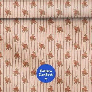 Pode incluir: Tecido com um padrão repetitivo de ursos castanhos a usar cachecóis vermelhos com bolinhas brancas, sobre um fundo de riscas verticais vermelhas numa base creme. Um logótipo circular azul com o texto Pattern Confetti é visível.