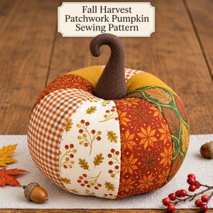 May include: A fabric pumpkin featuring a patchwork design with various autumn-themed patterns including brown gingham, cream with berries, orange geometric stars, and green leaves. It has a dark brown herringbone stem and text above reading Fall Harvest Patchwork Pumpkin Sewing Pattern.