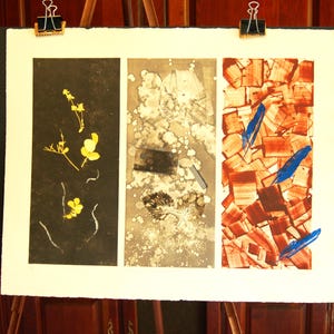 May include: A triptych art print on white paper featuring three vertical panels. The left panel is black with yellow botanical silhouettes. The center panel is a gray and white abstract wash with leaf imprints. The right panel has a red-brown geometric pattern with bright blue brushstrokes.