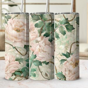 May include: Three stainless steel insulated tumblers with floral designs. The tumblers feature a cream background with large pink peonies, green leaves, and gold-colored vines. Each tumbler has a silver lid and a straw.