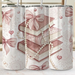May include: A stainless steel tumbler with a watercolor design featuring stacked books, bows, and pearls in shades of pink and white. The design includes hearts and a delicate lace pattern, creating a romantic theme.