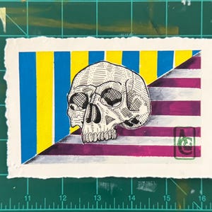 May include: A detailed pen and ink drawing of a skull is centered on a watercolor painting. The background is split diagonally, with blue and yellow vertical stripes on one side and purple and white stripes on the other.
