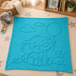 Puede incluir: Una manta cuadrada de ganchillo en color turquesa brillante con un diseño texturizado de punto bobble. El patrón muestra un elefante central sosteniendo un globo, rodeado por dos nubes, una pequeña mariposa y hierba en relieve.
