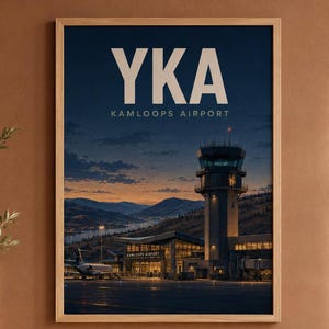 Op de afbeelding: Een ingelijste reisposter met een donkerblauwe schemering van Kamloops Airport, gelabeld YKA. De afbeelding toont een verkeerstoren, een luchthavengebouw en een geparkeerd vliegtuig tegen een achtergrond van bergen.