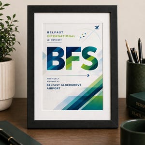 May include: Framed print of Belfast International Airport, displaying the airport code "BFS" in bold, colourful lettering. The design includes geometric shapes in shades of blue and green, with the text "Formerly known as Belfast Aldergrove Airport."