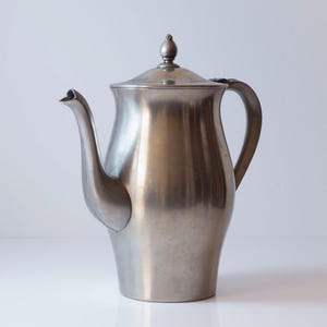 May include: A set of three ceramic mugs with a speckled, matte finish. The mugs are in shades of cream, light gray, and dark gray. Each mug has a simple, minimalist design, perfect for coffee or tea.