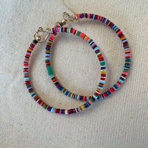 May include: A pair of hoop earrings with a colorful, beaded design. The earrings feature a variety of colors, including red, pink, blue, green, and yellow. The hoops are made of small, flat beads strung together on a wire.