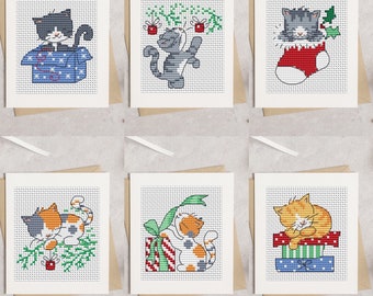 May include: Six Christmas cards featuring cute cats in various holiday scenes. The cards are white with a white border and feature a variety of colours, including red, green, blue, and orange.