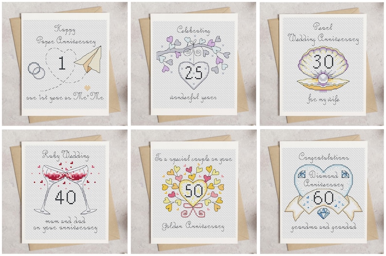 May include: A collection of handmade anniversary cards with cross-stitch designs. Each card features a different milestone, including the 1st, 25th, 30th, 40th, 50th, and 60th anniversaries, with corresponding text and imagery like hearts, rings, and champagne glasses.