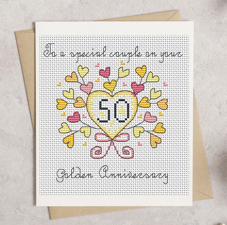 May include: A cross-stitch anniversary card with a heart-shaped design. The heart is yellow and contains the number 50, surrounded by yellow and pink hearts and leaves. The card reads "To a special couple on your Golden Anniversary."