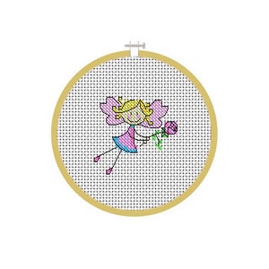 May include: A cross-stitch embroidery hoop featuring a whimsical fairy design. The fairy has blonde hair, pink wings, and a blue and pink dress, holding a pink rose. The embroidery is set in a round, wooden hoop.