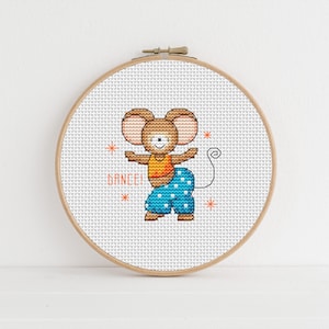 Op de afbeelding: Een borduurring met kruissteek met een ontwerp van een bruine muis die een blauwe broek met witte stippen en een oranje shirt draagt. De muis danst en de tekst "Dance!" is onder de muis geborduurd.