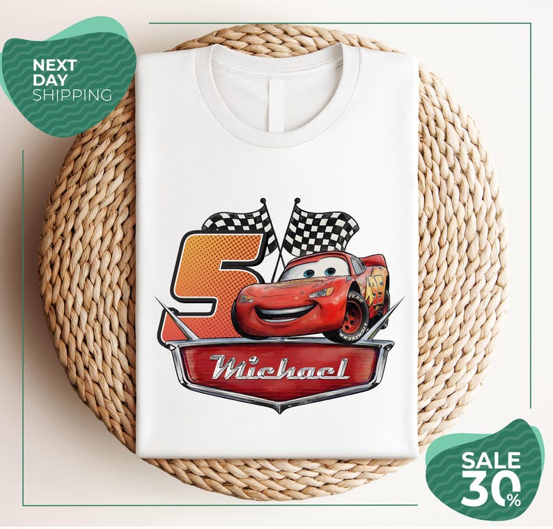 A white t-shirt with a graphic design featuring a red car and checkered flags, along with the text "Michael" and "Sale 30%".