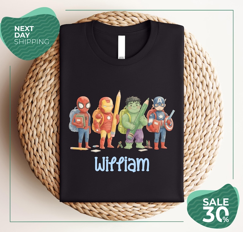 A black t-shirt with a colorful graphic design featuring four superhero characters, including Spider-Man, Iron Man, Captain America, and Wiliam.