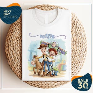 a white t-shirt with a cartoon illustration of characters from the Toy Story franchise, including Woody, Buzz Lightyear, and a horse. The t-shirt is displayed on a woven placemat, and there are two sale signs indicating a 30% discount on the item.