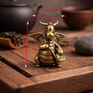 May include: A detailed brass dragon figurine, 1.377 inches tall and 0.866 inches wide, with horns, wings, and a satchel. The dragon is posed on a wooden surface, suggesting a decorative or collectible item.