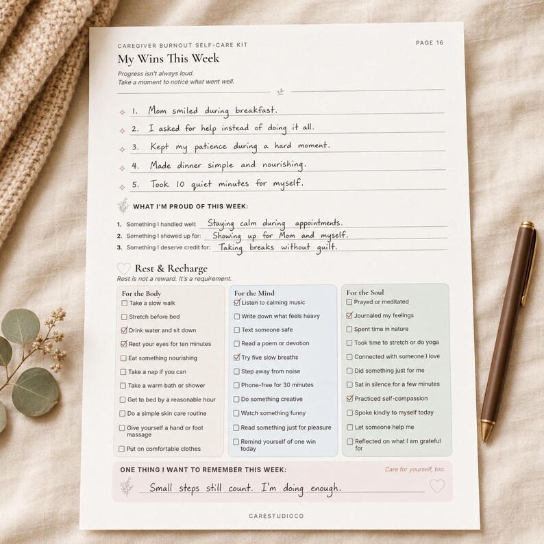 My Wins This Week caregiver self-care worksheet filled with handwritten reflections and checked rest activities on soft beige fabric with a pen and dried flowers.