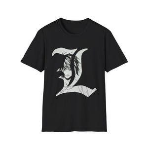 May include: Black t-shirt featuring a stylized illustration of a character within a large, white letter "L". The graphic is a detailed, grayscale portrait. The shirt is a classic crew neck style.