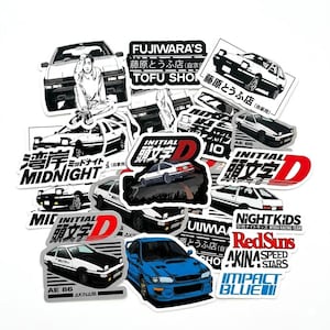 May include: A collection of stickers featuring Japanese anime-style car designs. The stickers include various car models, text in Japanese and English, and the words "INITIAL D", "AE 86", "MIDNIGHT", and "IMPACT BLUE". The stickers are white, black, red, and blue.
